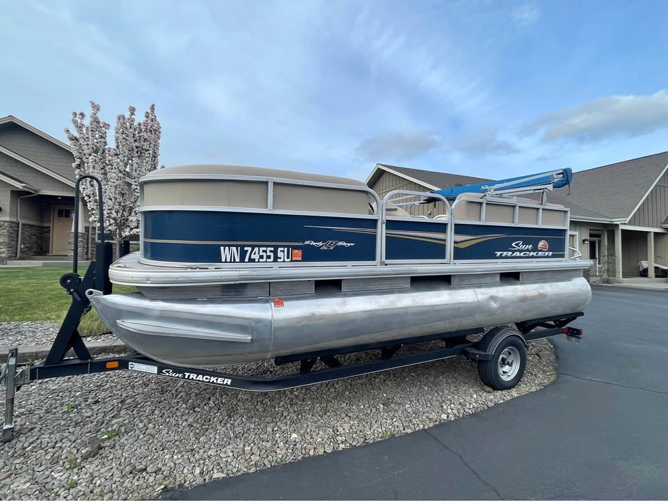 The Float Fund — Sun Tracker Party Barge on trailer, full side profile